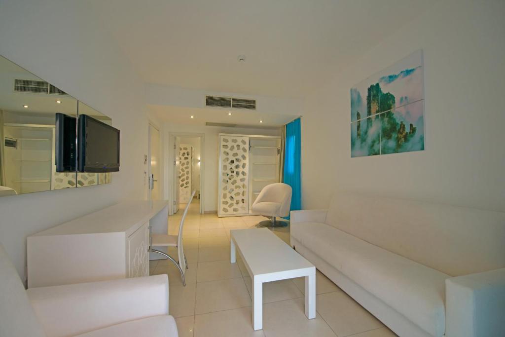 a white living room with a couch and a table at Costa Luvi Hotel Bodrum - All Inclusive in Gümbet