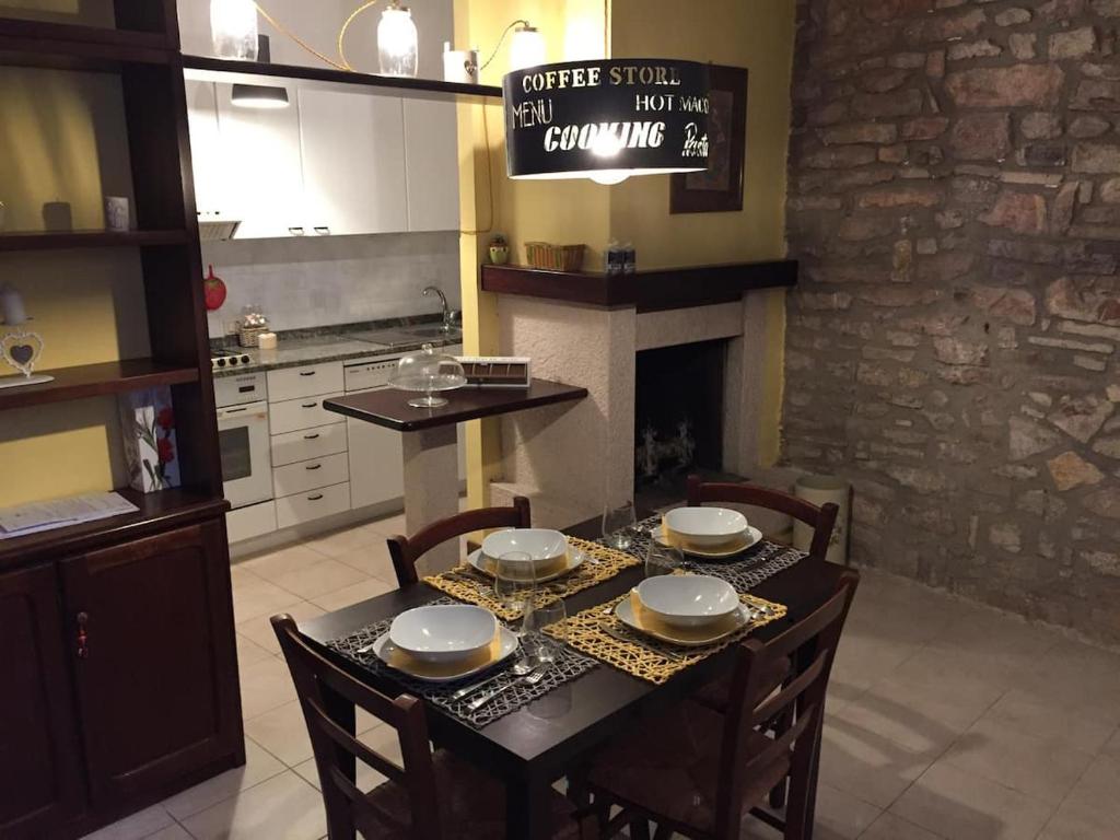 a dining room with a table with chairs and a fireplace at Francesco House Family in Assisi