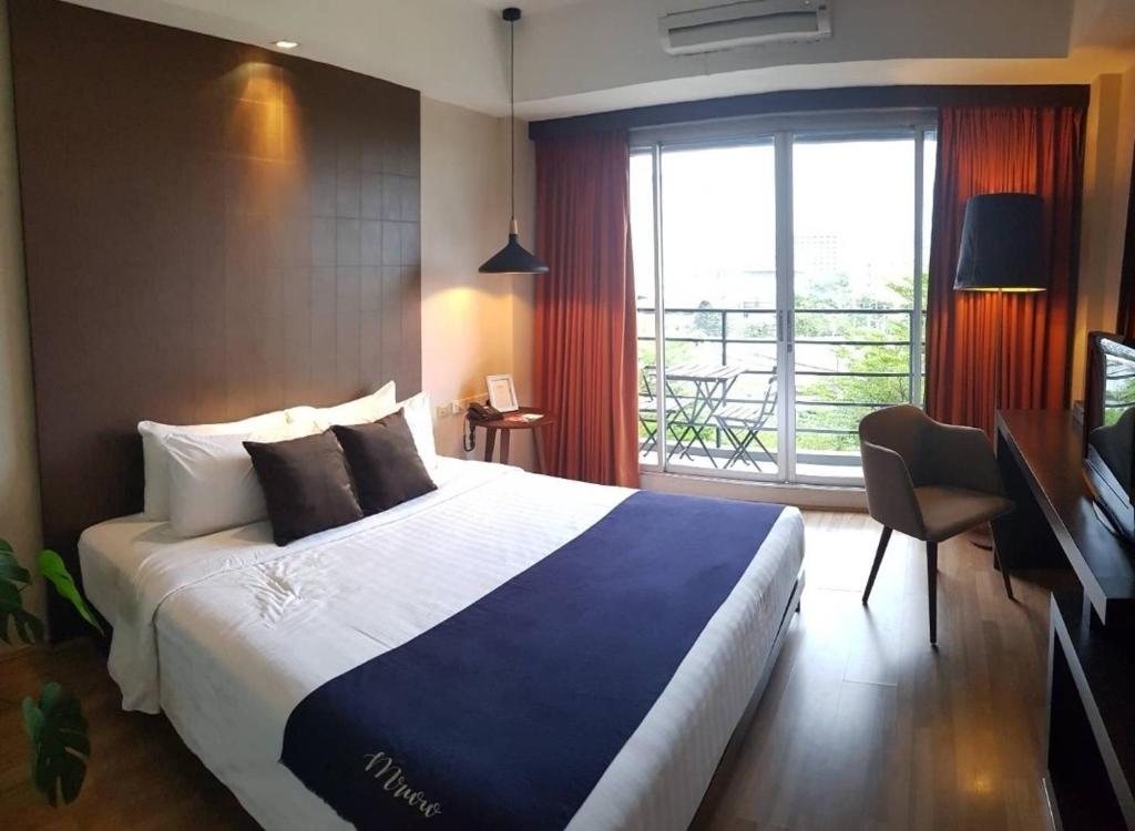 a hotel room with a bed and a window at Manita Boutique Hotel in Pattaya South