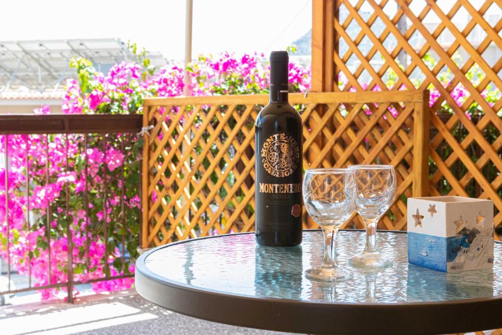 Stella Rooms في تولو: زجاجة من النبيذ موضوعة على طاولة مع كأسين