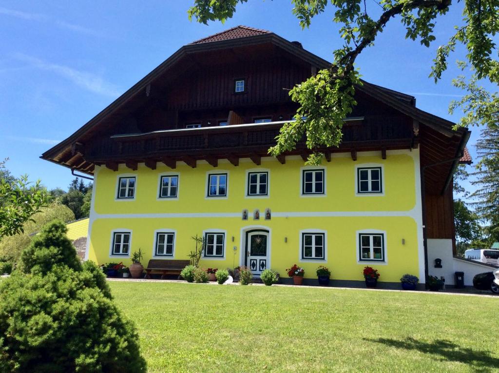 a yellow house with a brown roof at Eisenstattgut Faistenau in Faistenau