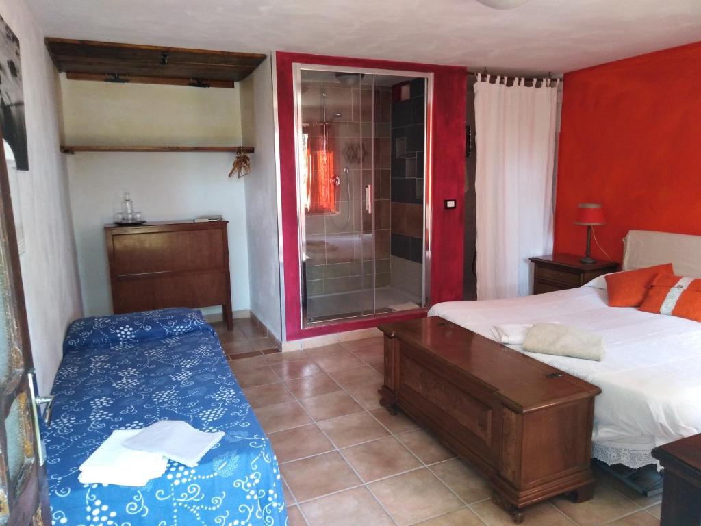 a bedroom with two beds and a glass shower at Bed & Relax Sinestesia in Precicchie