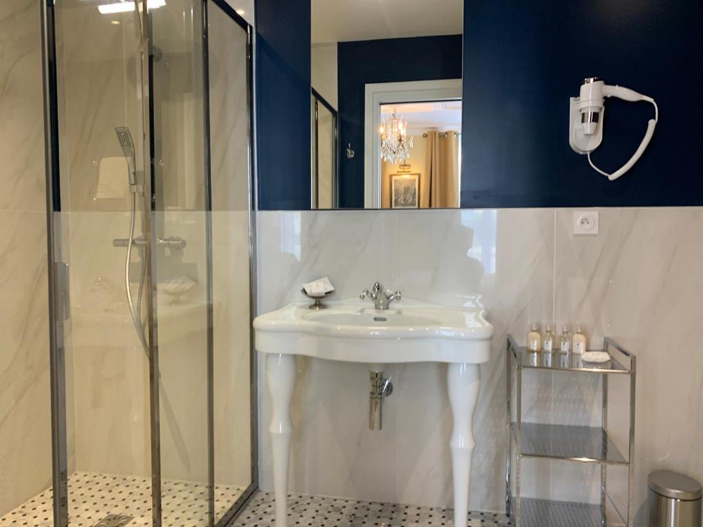 a bathroom with a sink and a shower at Le Tardif, Noble Guesthouse in Bayeux