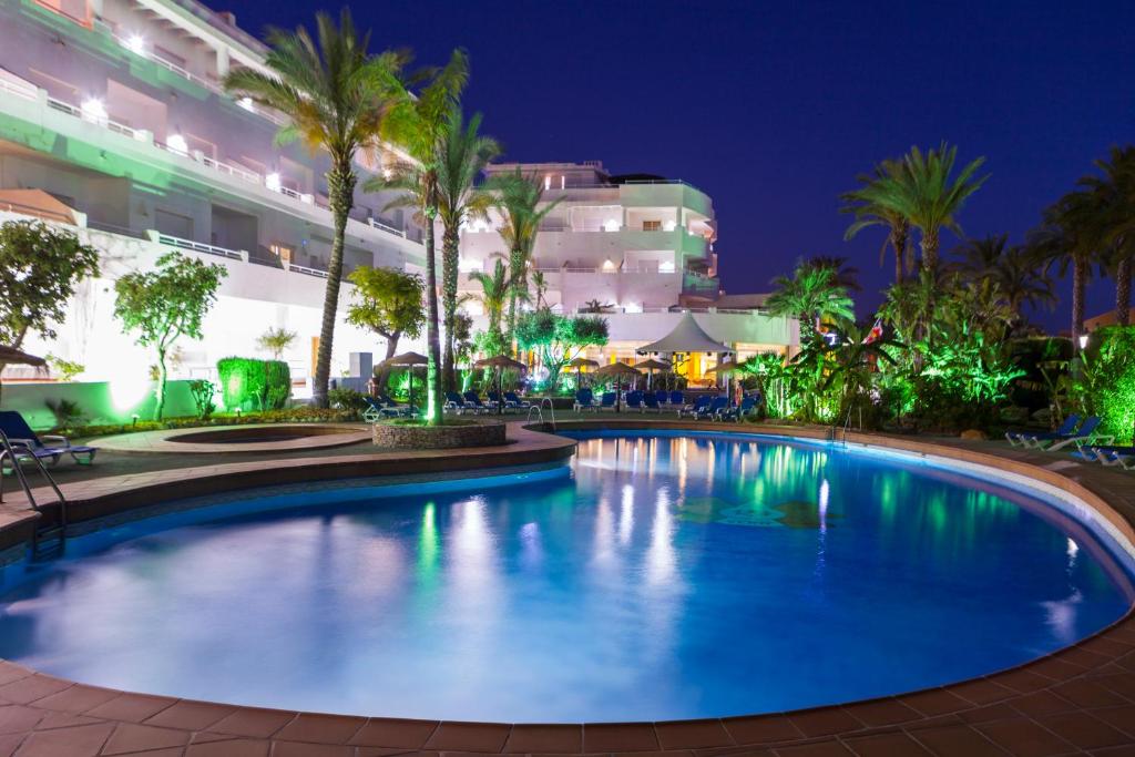 a swimming pool in a resort at night at Apartamentos Mexico in Vera