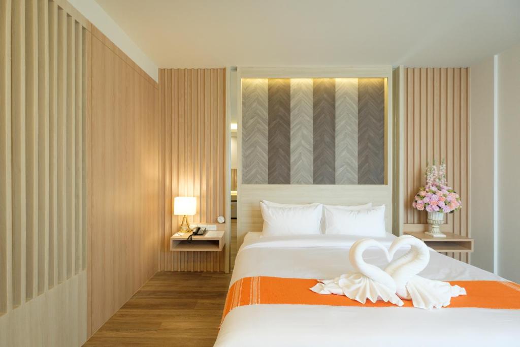 een hotelkamer met een bed met handdoeken erop bij Monte Maesot hotel in Mae Sot