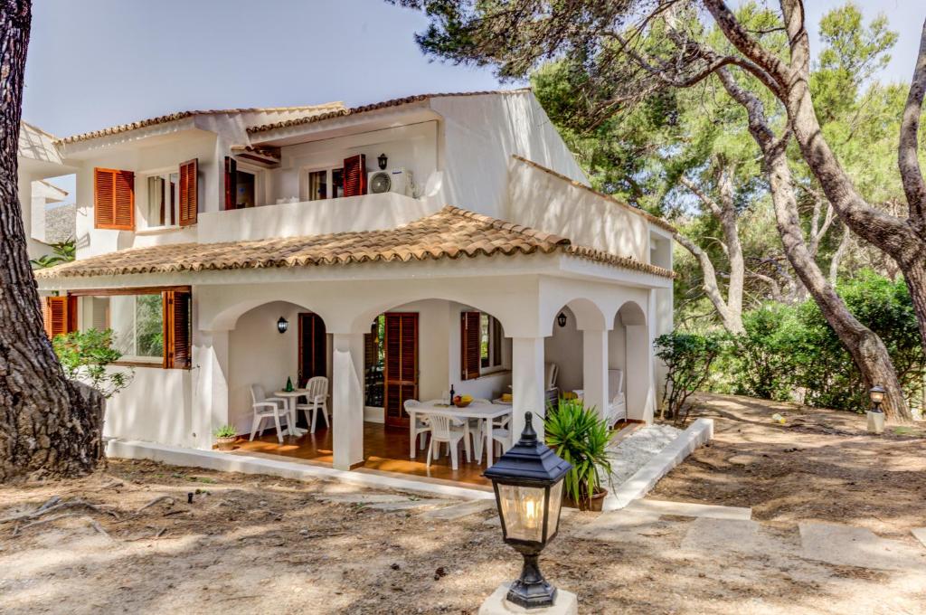 a white house with a table in front of it at Villa Cala San Vicente - Can Botana 6 in Cala de Sant Vicent