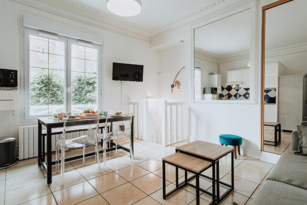 een woonkamer met een tafel en stoelen. bij 30 mètres de la plage et des planches. Tout à pied ! in Trouville-sur-Mer