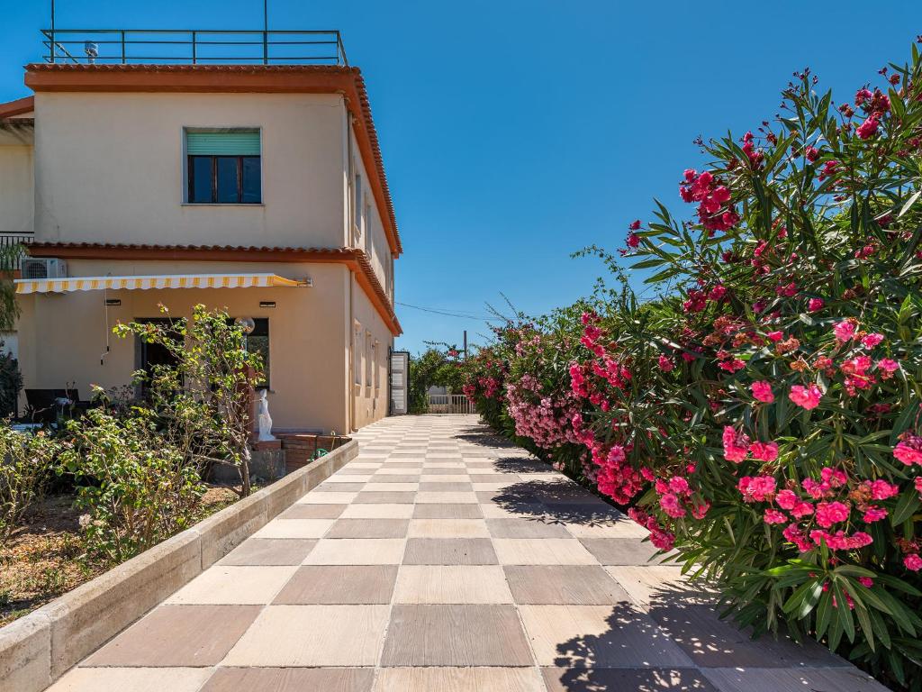 a walkway leading to a building with pink flowers at Casa Nunzia in SantʼAndrea