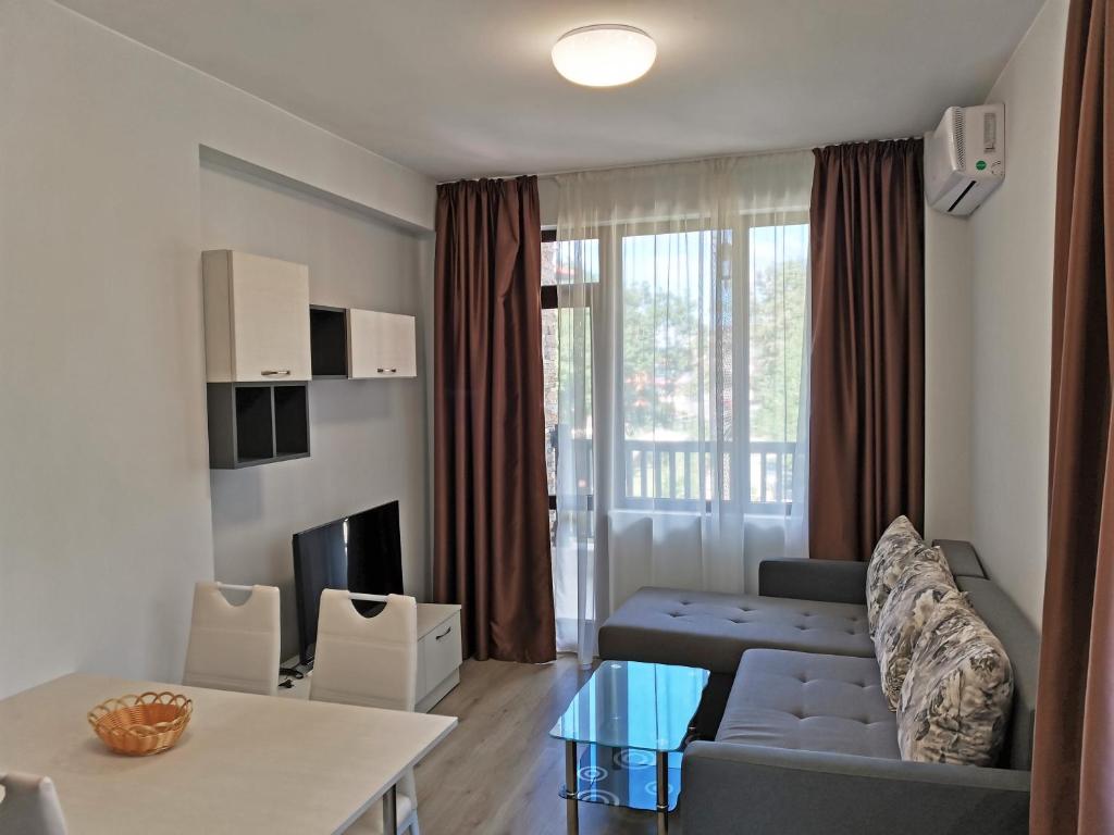 a living room with a couch and a table at Family Apartment for Short-Term Vacation in Primorsko