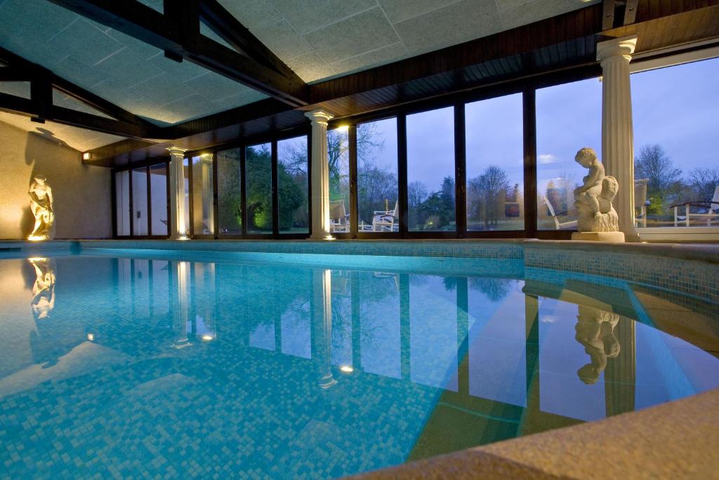 a swimming pool with a statue in a building at Relais du Bois Saint Georges - Hôtel de Charme in Saintes