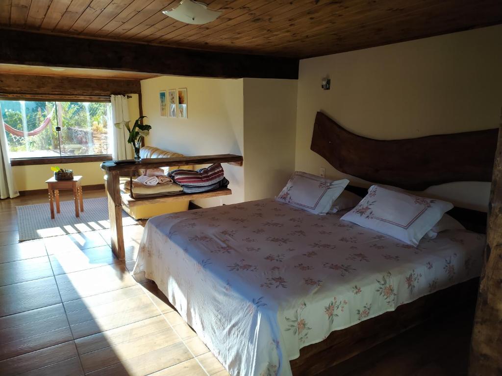 a bedroom with a large bed with a wooden headboard at Brisa de Lavras in Lavras Novas