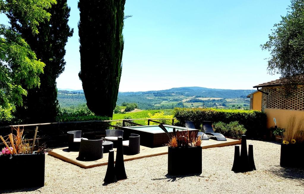 ガンバッシ・テルメにあるIl Leccio - Casa Toscana San Gimignanoの庭園内のパティオ(椅子付)、ホットタブを利用できます。