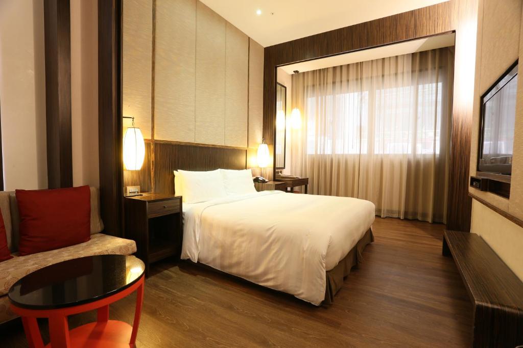 a hotel room with a bed and a table and a couch at City Suites - Taipei Nandong in Taipei