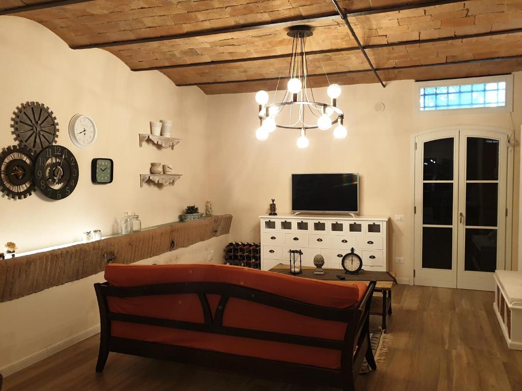 salon z kanapą, stołem i telewizorem w obiekcie Il Leccio - casa toscana il fienile w mieście Gambassi Terme