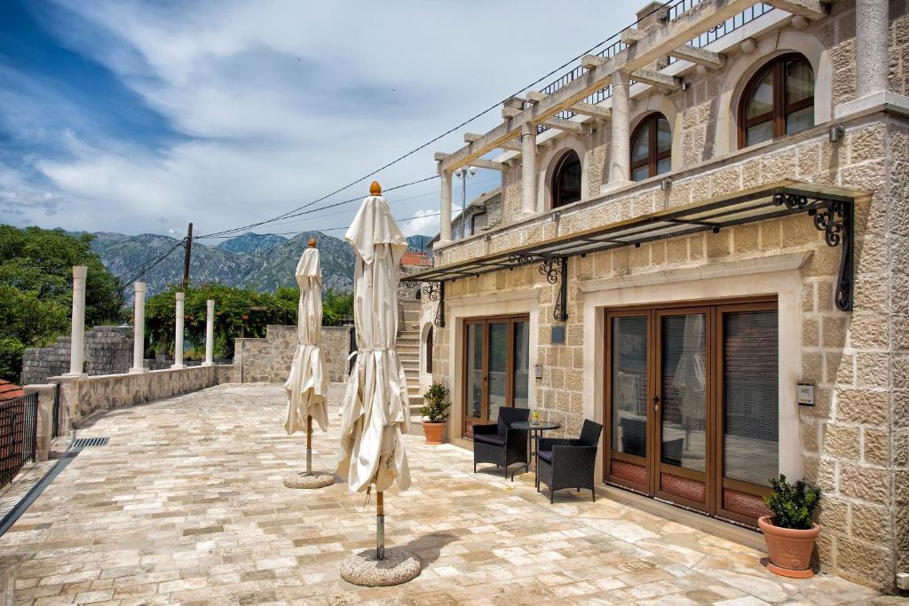 un patio con 2 sombrillas en un edificio en Apartments Admiral, en Perast