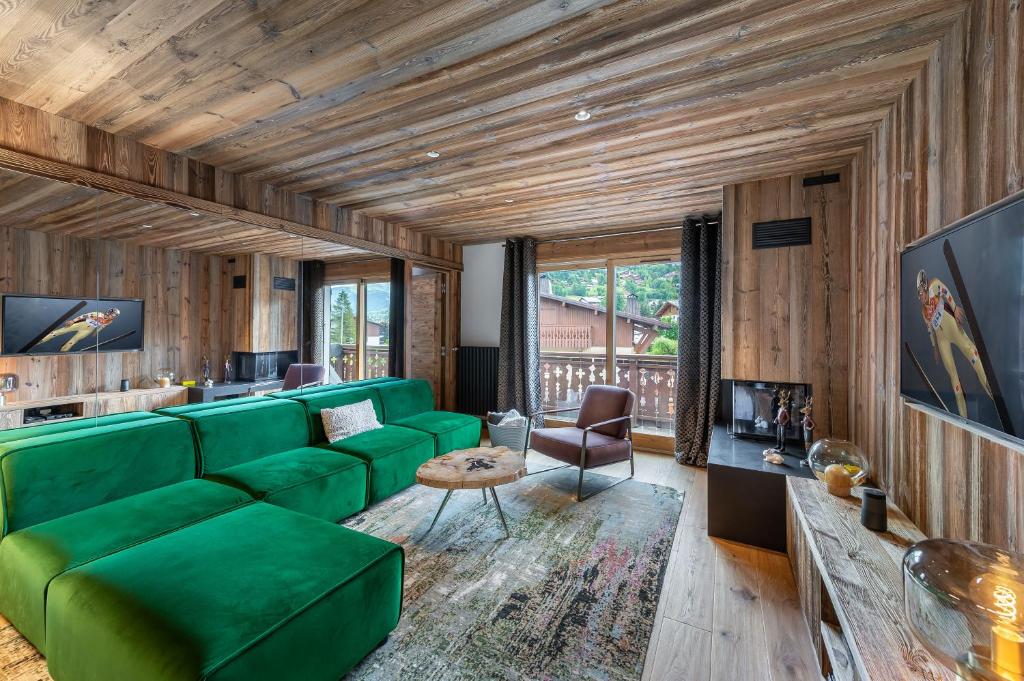 sala de estar con sofá verde y ventana grande en MEGEVE Jaillet 3 chambres 6 personnes, en Megève