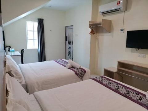 Postel nebo postele na pokoji v ubytování LH Hotel Langkap Perak