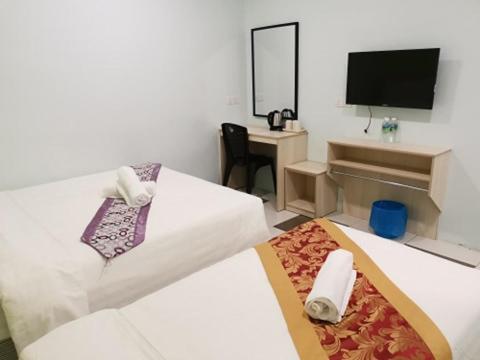 Postel nebo postele na pokoji v ubytování LH Hotel Langkap Perak