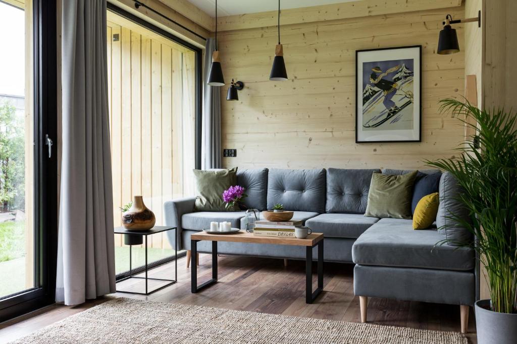 uma sala de estar com um sofá azul e uma mesa em Mount Apart Center em Zakopane