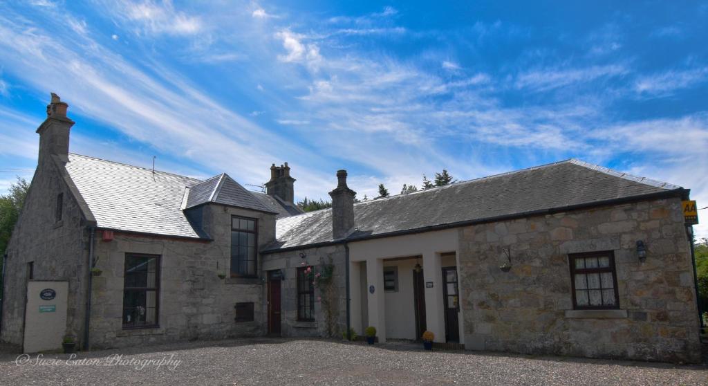 un antiguo edificio de piedra con un cielo azul en el fondo en Clarke Cottage Guest House en Dunfermline