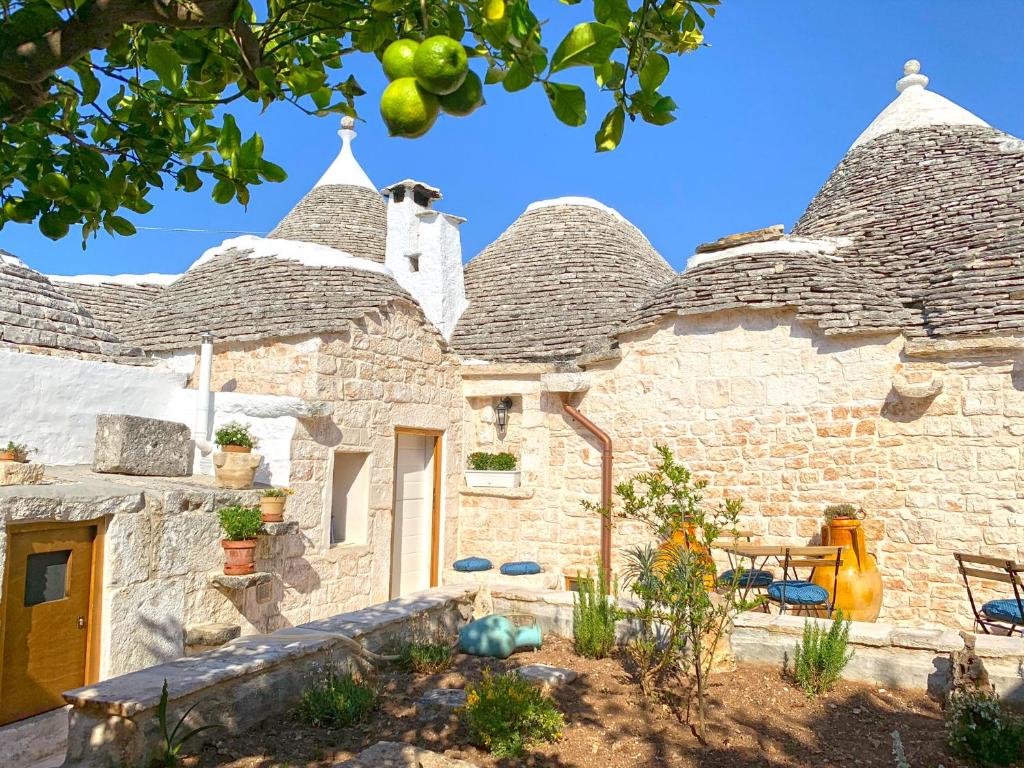 a stone house with a garden in front of it at Trullo Aprìco in Alberobello