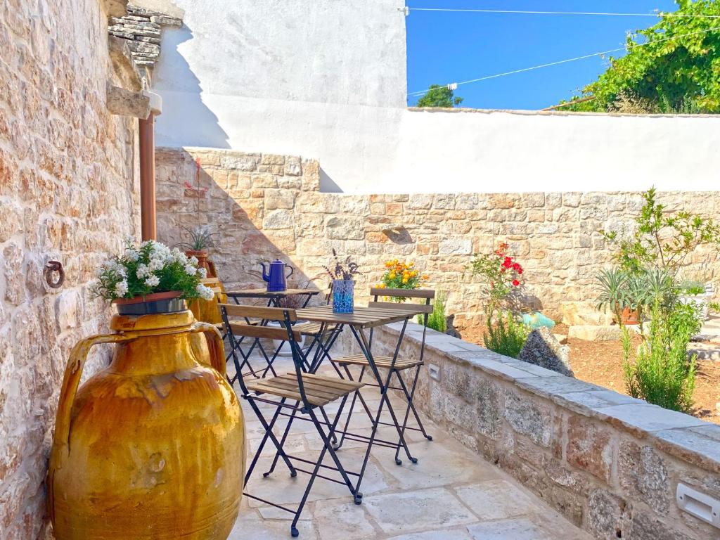 a patio with a table and a large vase at Trullo Aprìco in Alberobello