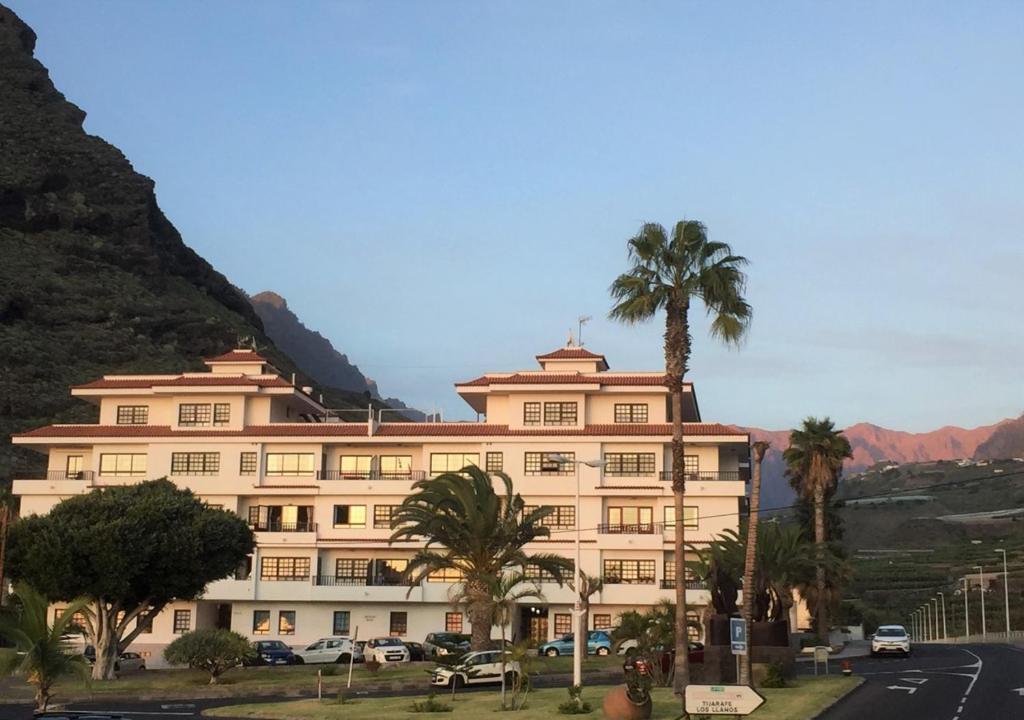 ein großes Gebäude mit Palmen vor einem Berg in der Unterkunft Apartamento Sol y Mar in Tazacorte