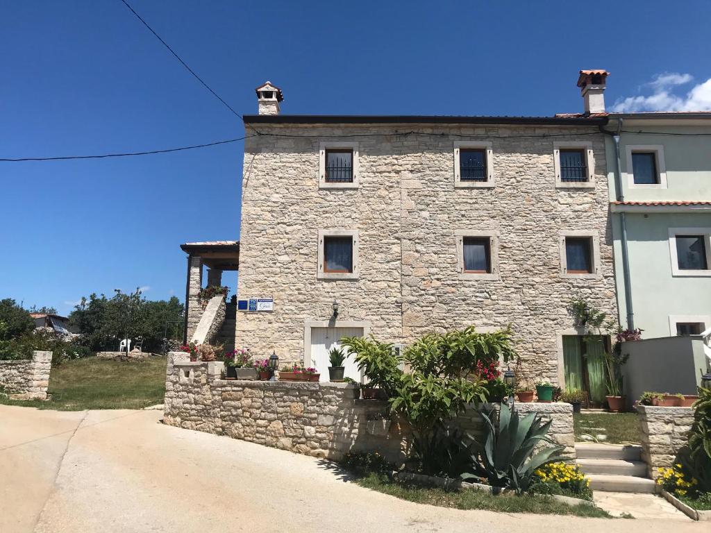a stone building with a stone wall in front of it at APP GAŠI in Buje