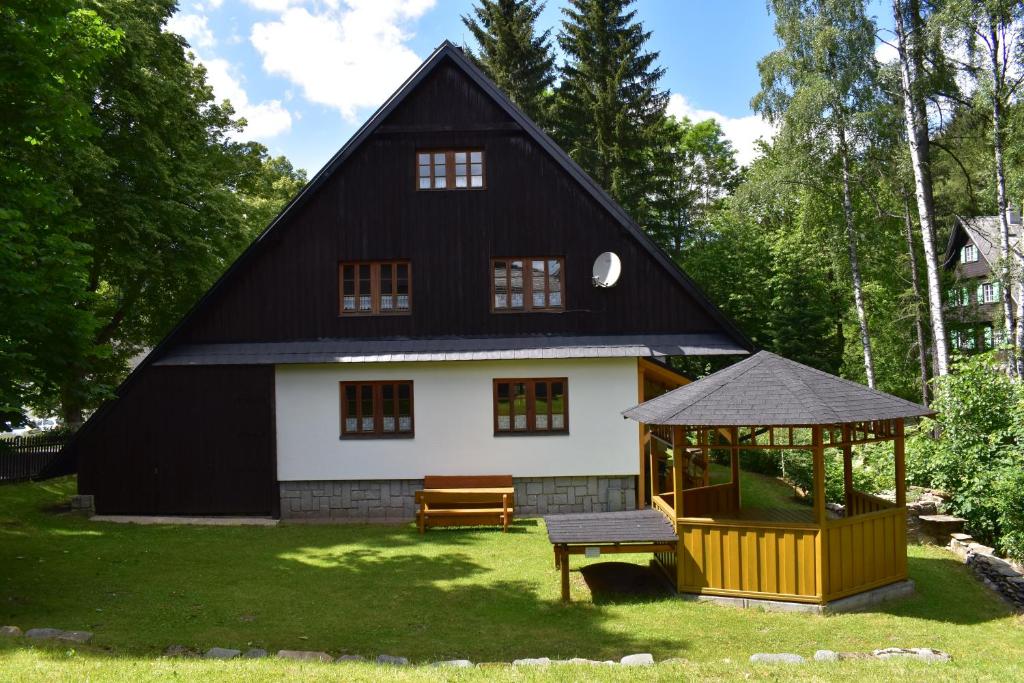 ein schwarzweißes Haus mit einem Pavillon in der Unterkunft Chata U Janka in Bělá pod Pradědem