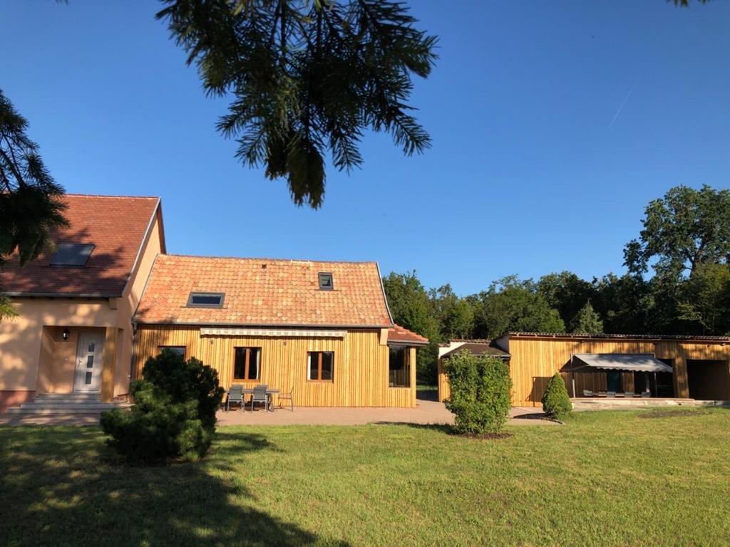 een groot houten huis met een grote tuin bij Le Clos Ô Daims in Widensolen