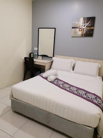 Postel nebo postele na pokoji v ubytování LH Hotel Langkap Perak