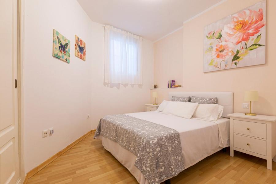 a white bedroom with a bed and a window at Homefeel Museo in Seville