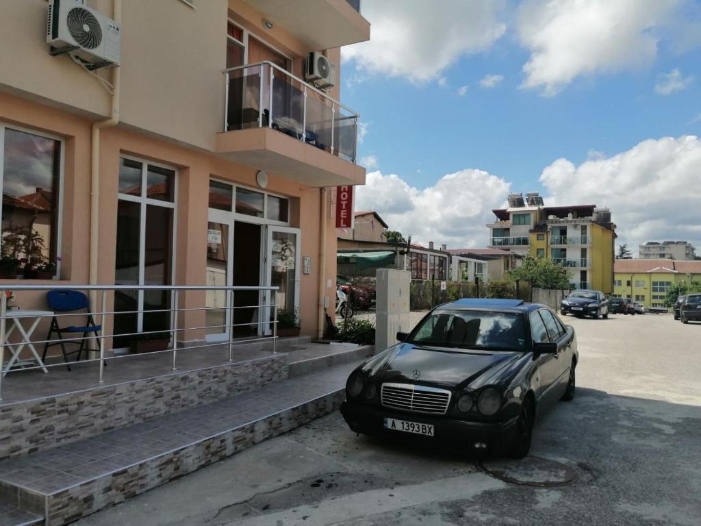 um carro preto estacionado em frente a um edifício em Къща за гости Диана ДИК em Kiten