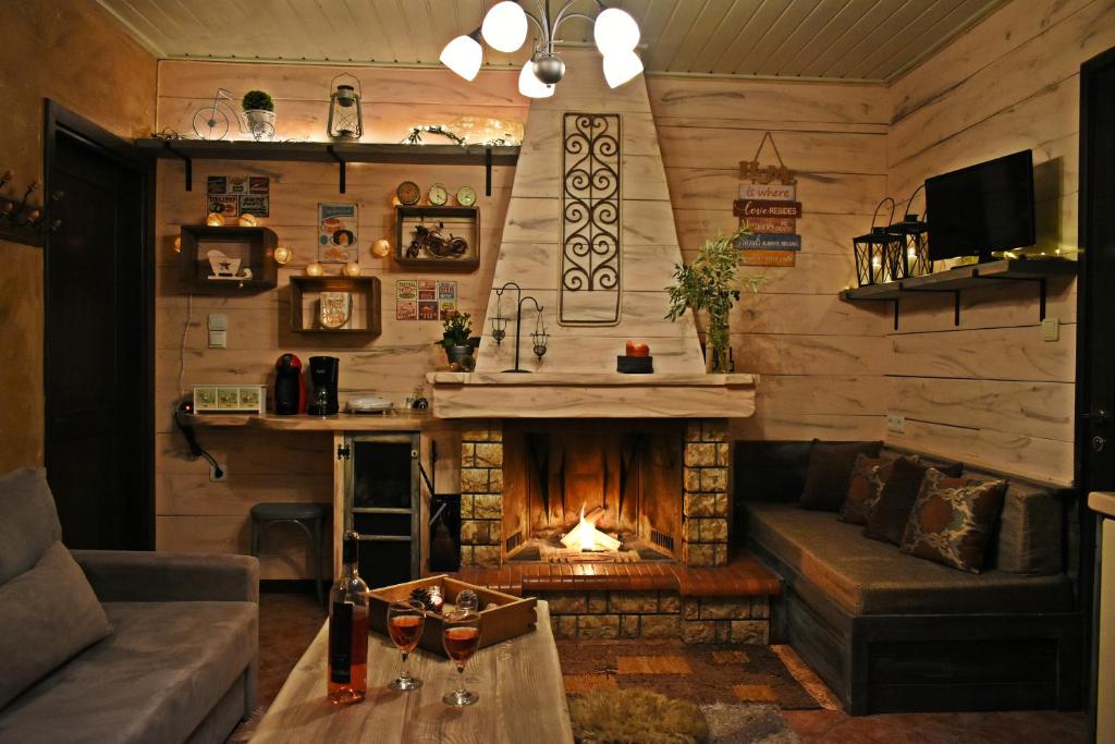 ein Wohnzimmer mit einem Kamin in einer Blockhütte in der Unterkunft Agiaz' in Arachova