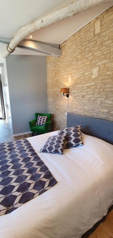1 dormitorio con 1 cama grande y 1 silla verde en Les 5 rûches en Courseulles-sur-Mer