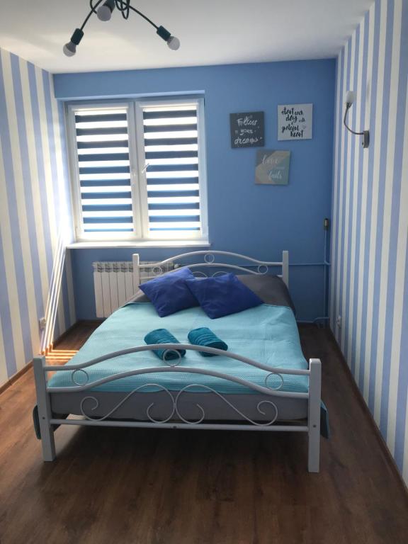 ウェバにあるApartament Lazurのベッドルーム1室(青い壁のベッド1台、窓付)