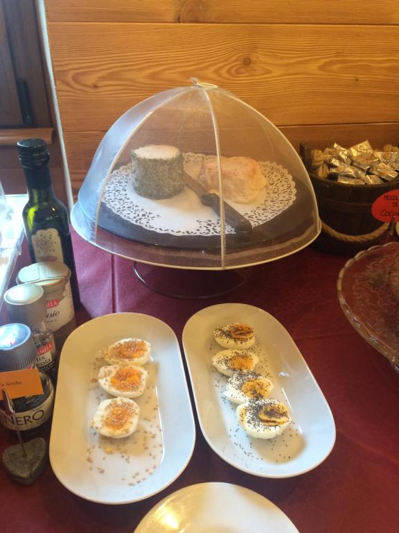 einem Tisch mit drei Teller Essen in einer Glaskuppel in der Unterkunft Green Hotel Herbetet in Cogne