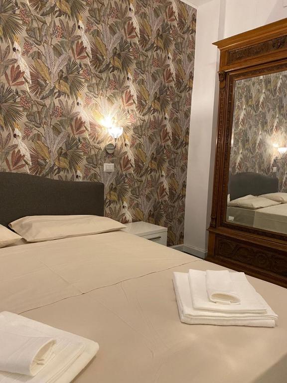 Un dormitorio con una cama y un espejo grande. en Al Teatro, en Reggio Calabria