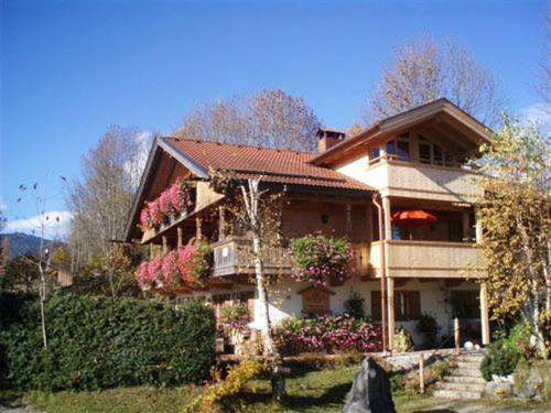 Una casa grande con flores al costado. en Landhaus Am Arzbach, en Bad Tölz