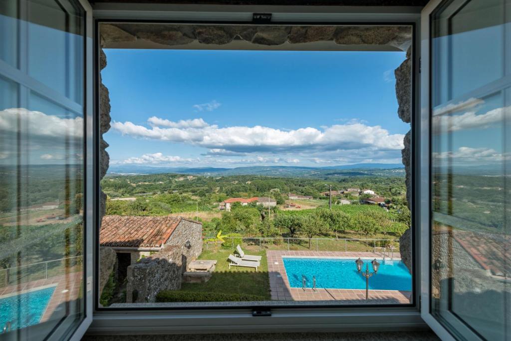 een uitzicht vanuit het raam van een villa met een zwembad bij Aldeade in Ferreira
