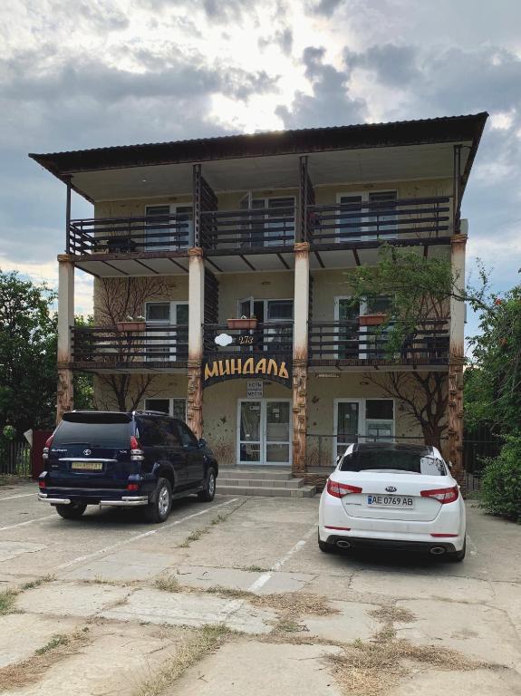two cars parked in a parking lot in front of a building at Миндаль in Zatoka