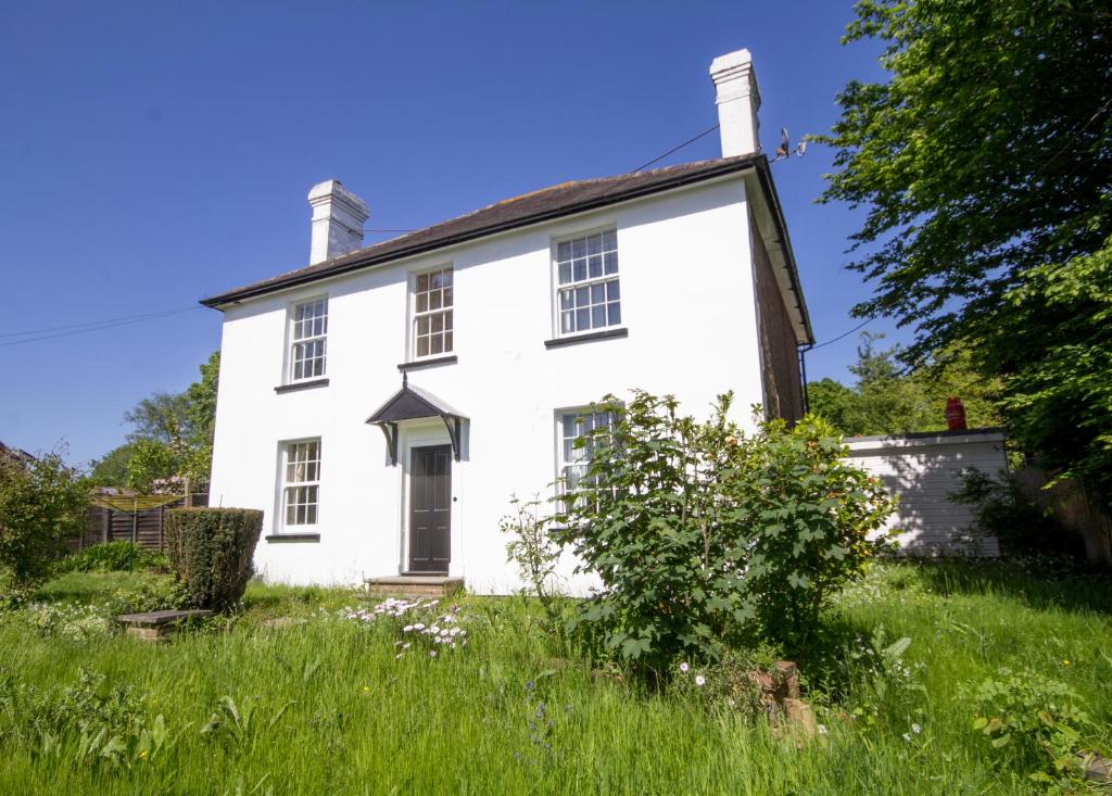 an old white house in a field of grass at 4 bed family house with aga in Battle