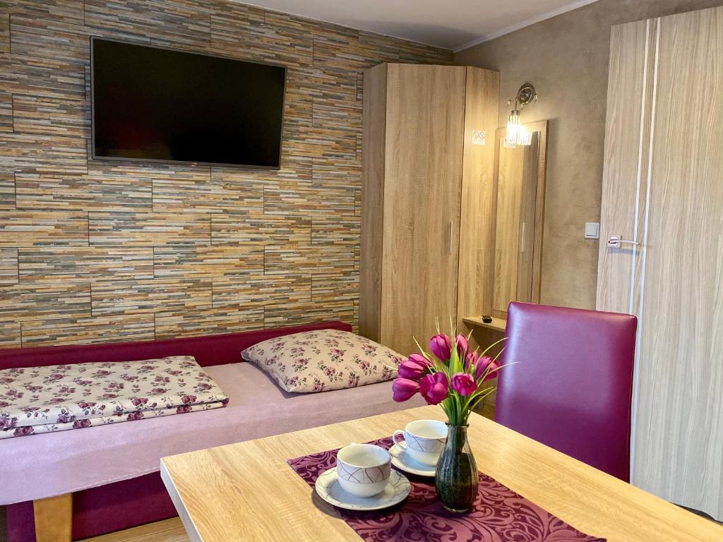 ein Zimmer mit einem Sofa und einem Tisch mit Blumen darauf in der Unterkunft Klinkierowa Rezydencja Gniezno in Gniezno