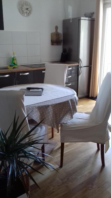 une cuisine avec une table et deux chaises blanches dans l'établissement Apartment Mime Blata, à Vodice