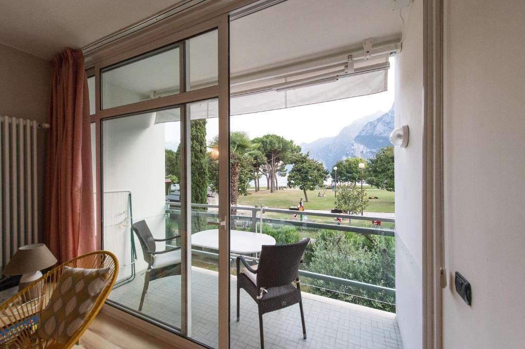 Habitación con balcón con mesa y sillas. en Appartement Balcone sul Lago, en Riva del Garda