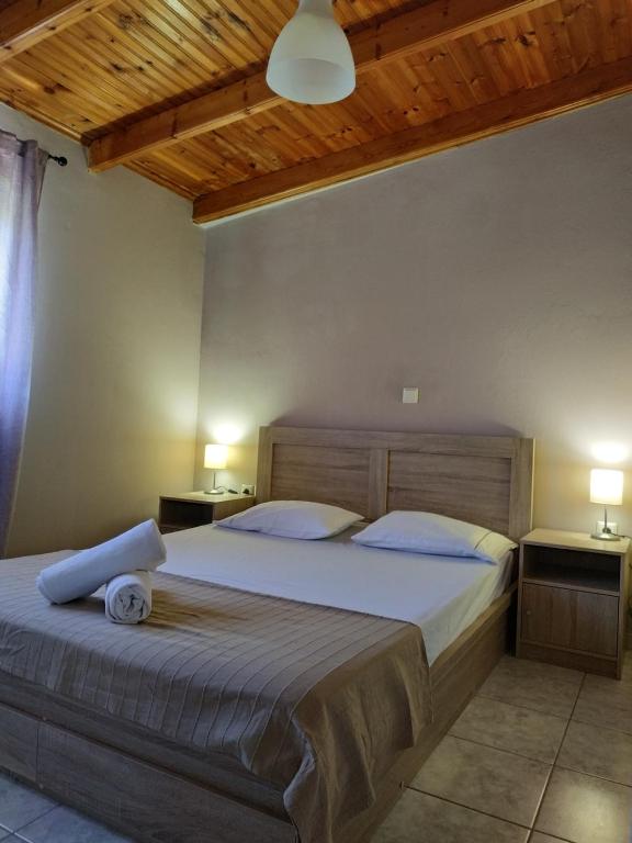 een slaapkamer met een groot bed met een houten hoofdeinde bij Vravrona Artemis Home & Transfer Airport in Artemida