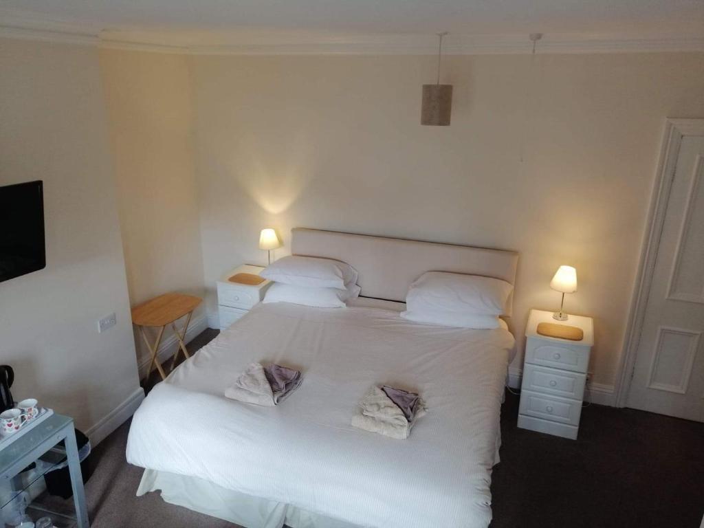 a bedroom with a white bed with two pillows at Prospect House in Whitby