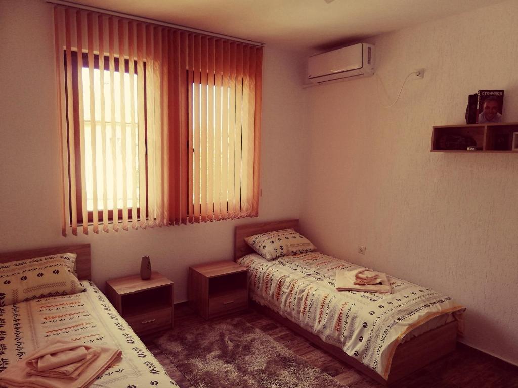 a bedroom with two beds and a window at Petrov Apartment in Tryavna