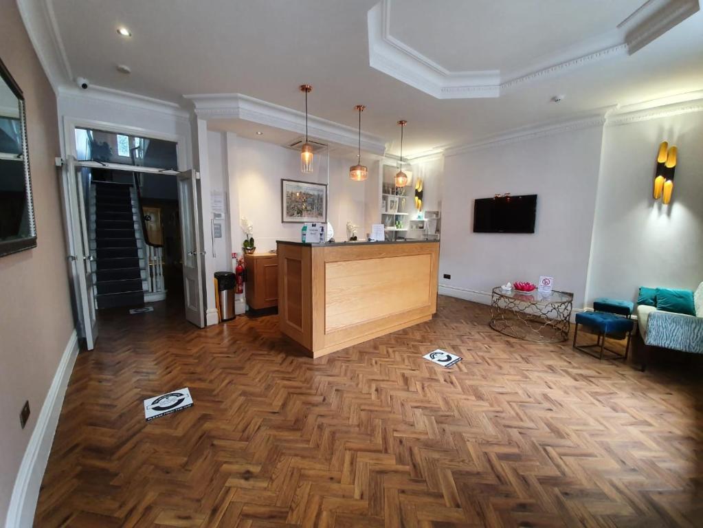 sala de estar con suelo de madera y cocina en The Beverley Hotel London - Victoria, en Londres