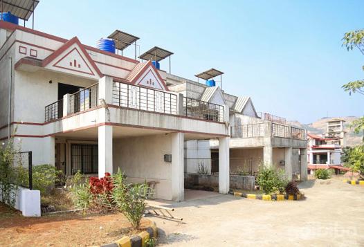 ein großes weißes Gebäude mit Balkon darüber in der Unterkunft Aryan Bungalow 4BHK in Lonavla